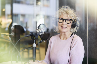 Mature woman sitting and hosting podcast or radio show or podcast