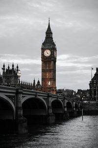 Big ben tower by westminster bridge against cloudy sky