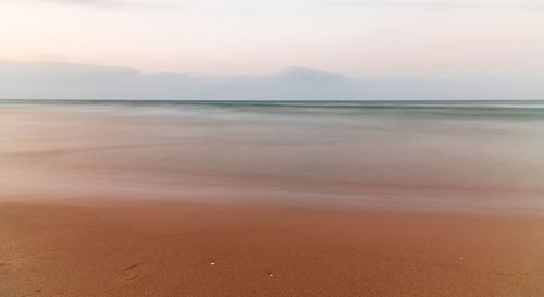 Scenic view of beach against sky during sunset