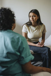 Female doctor discussing with young woman in clinic