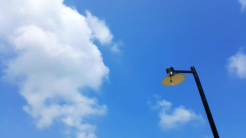 Low angle view of lighting equipment against blue sky