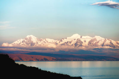 Scenic view of lake by mountains against sky