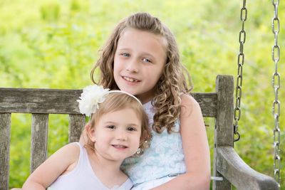 Portrait of happy girls sitting in park