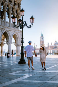 Rear view of people walking in historic building