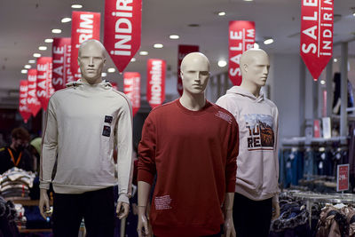 Mannequins and discount flags at the entrance of the textile store.