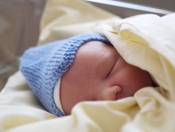 Close-up of baby sleeping in bed