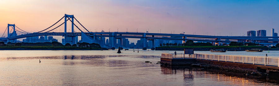 Bridge over river at sunset