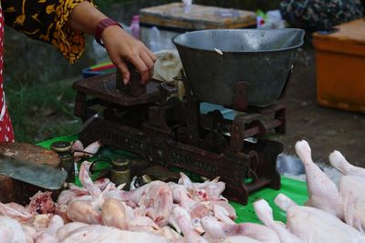 Cropped hand of man preparing food on barbecue grill