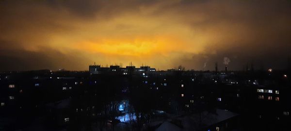 High angle view of silhouette buildings against sky at sunset