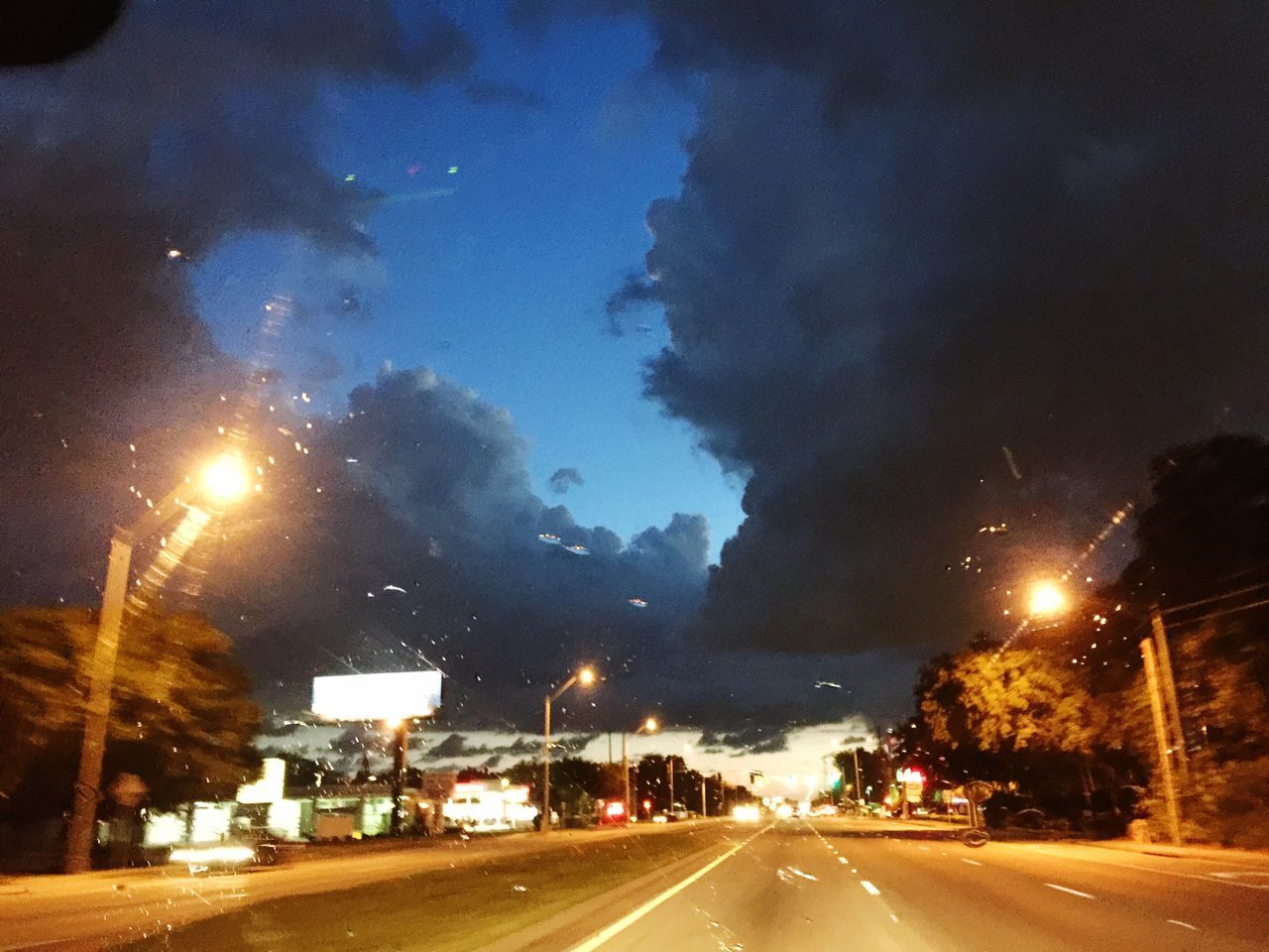 night, illuminated, road, transportation, sky, the way forward, street light, car, street, diminishing perspective, weather, road marking, wet, cloud - sky, dusk, land vehicle, vanishing point, rain, no people, outdoors