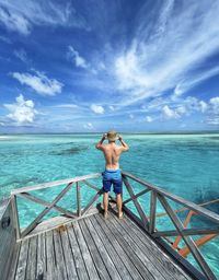 Rear view of woman looking at sea against sky