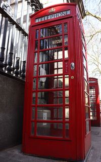 Red telephone booth by building