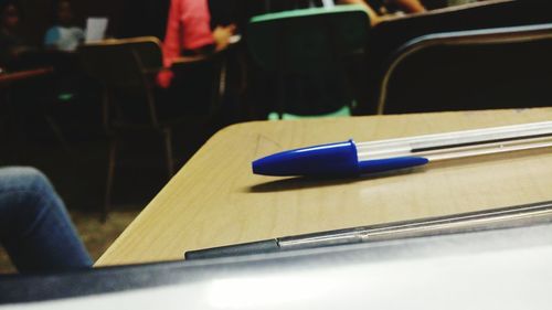 Midsection of person by pen on desk