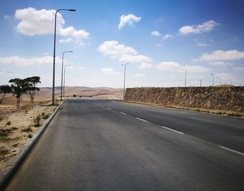 Empty road by street against sky