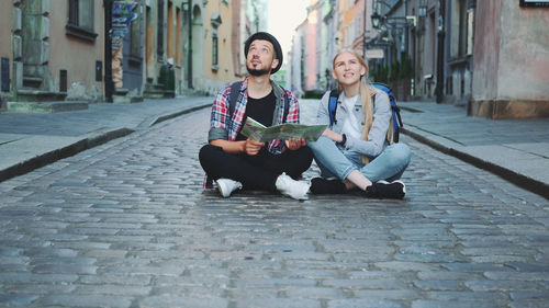 Women sitting on sidewalk in city