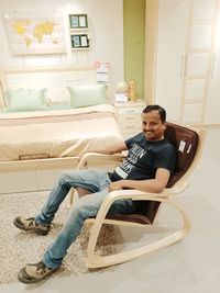 Portrait of smiling man sitting on rocking chair