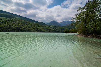 Scenic view of lake by mountains against sky