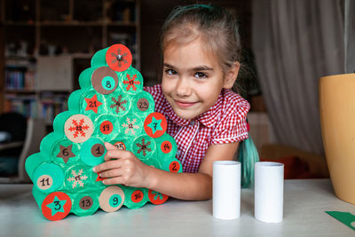Portrait of girl preparing christmas decoration at home