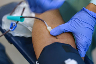 Cropped image of doctor preparing patient for blood donation