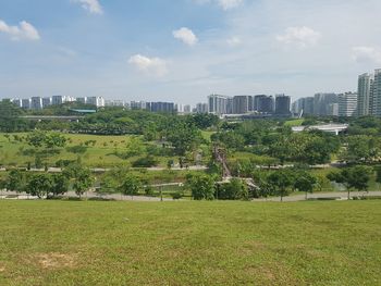 Scenic view of park in city against sky