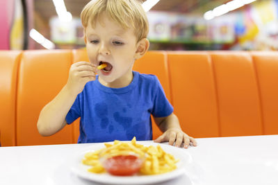 Portrait of boy eating food at home