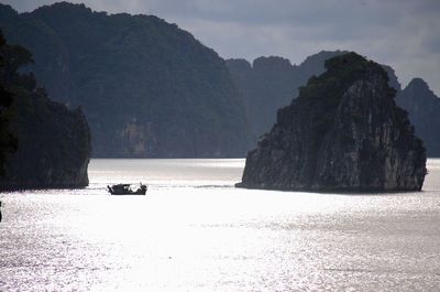 Scenic view of sea and mountains against sky