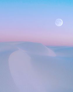 Scenic view of sand dunes in desert against sky during sunset