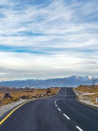 Empty road against cloudy sky