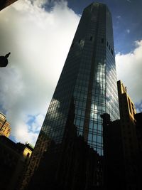 Low angle view of modern buildings against cloudy sky