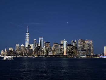 Illuminated buildings in city at waterfront