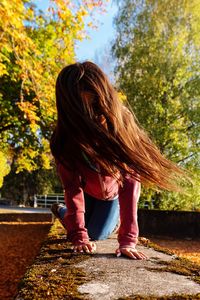 Girl climbing on old concrete wall