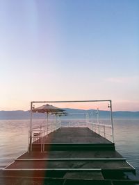 View of jetty over lake against sky during sunset