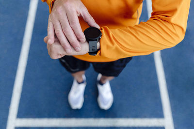 Hand of sportsman with smart watch on running track