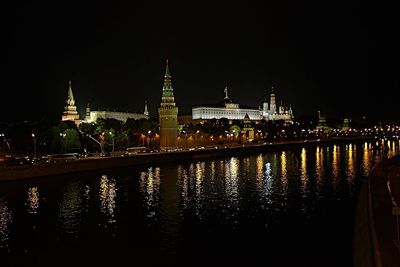 Illuminated bridge over river at night