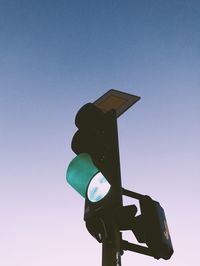 Low angle view of road signal against clear sky