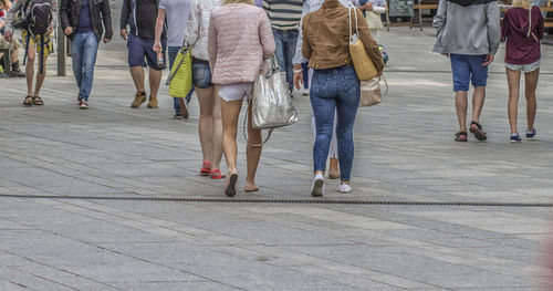 Low section of people walking on zebra crossing in city