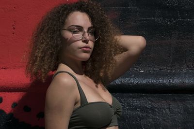 Portrait of young woman against wall