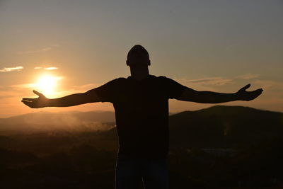 Silhouette man standing against sky during sunset