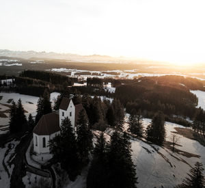 High angle view of trees and buildings against sky during sunset