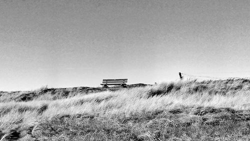 Grassy field against clear sky