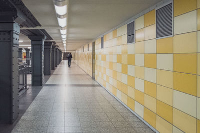 Man walking on illuminated corridor