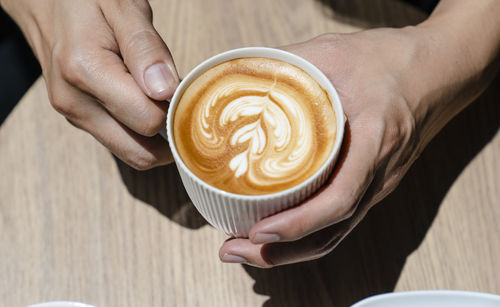 Midsection of woman holding coffee cup