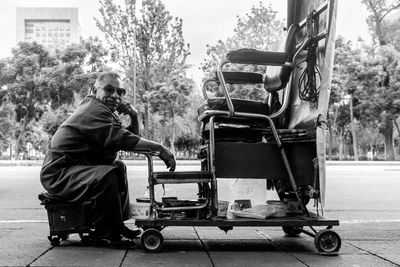 Man sitting on road in city