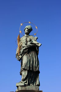 Low angle view of statue against blue sky