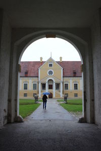 Rear view of man walking by building