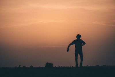 Silhouette man jumping against sky during sunset