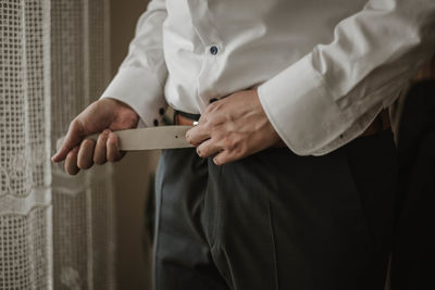 Midsection of man wearing belt