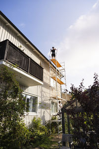 Men on scaffolding renovating house