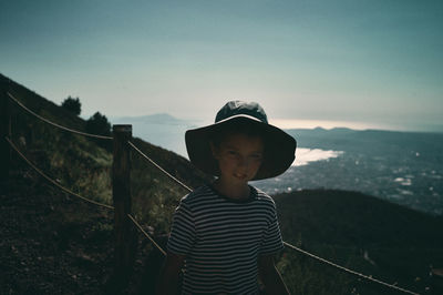 Gril with a sun hat on a day trip up a volcano trail