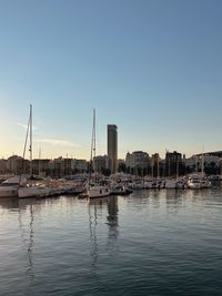 Boats in harbor against clear sky